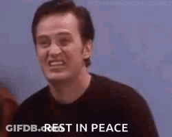 A Man Is Smiling And Saying `` Rest In Peace '' While Standing In Front Of A Group Of People . GIF