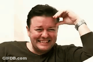 A Man Is Smiling And Touching His Forehead . GIF