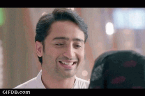 A Man Is Smiling At A Woman In A Black Hijab . GIF