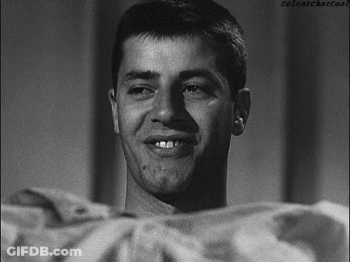 A Man Is Smiling In A Black And White Photo With Colonycharcoal Written Below Him GIF