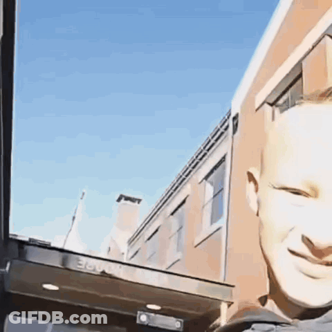 A Man Is Smiling In Front Of A Building That Has The Number 36 On The Side GIF