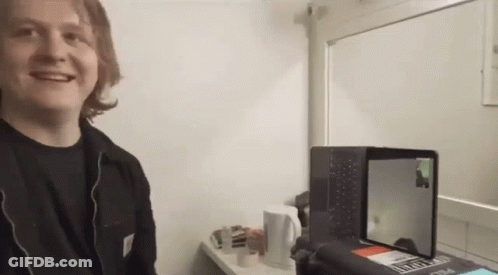 A Man Is Smiling In Front Of A Laptop That Says ' Sydney ' On The Screen GIF