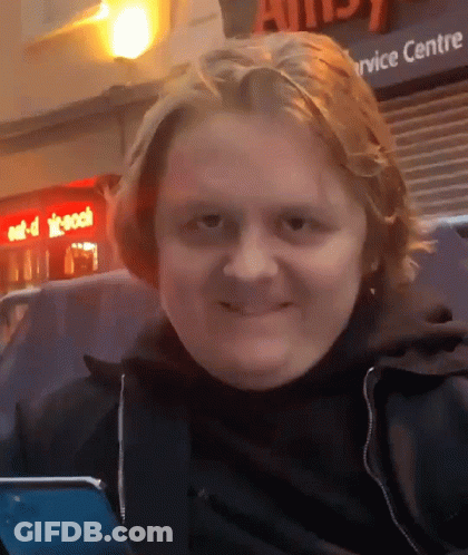 A Man Is Smiling In Front Of A Service Centre Sign GIF