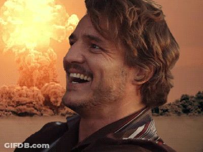 A Man Is Smiling In Front Of An Explosion GIF