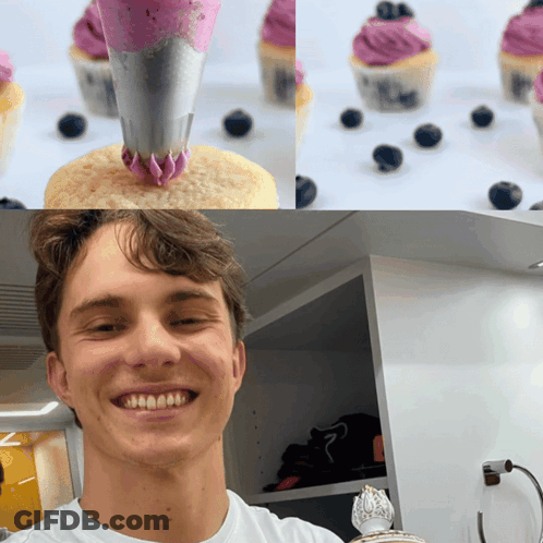 A Man Is Smiling In Front Of Cupcakes With Purple Frosting And Blueberries GIF