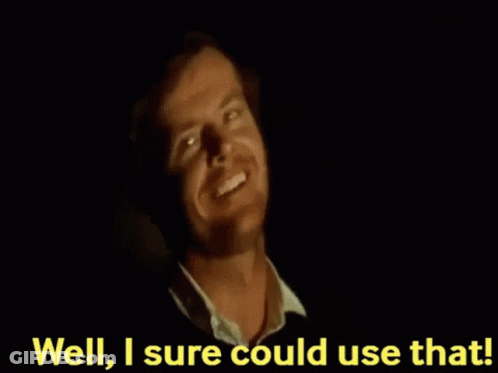 A Man Is Smiling In The Dark With The Words `` Well , I 'M Sure Could Use That '' Behind Him . GIF