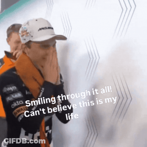 A Man Is Smiling Through It All While Covering His Face With His Hands . GIF