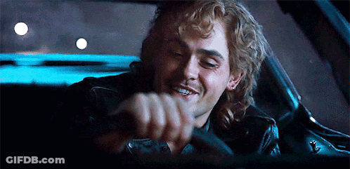 A Man Is Smiling While Driving A Car At Night . GIF