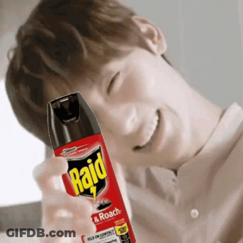 A Man Is Smiling While Holding A Bottle Of Raid Insect Spray GIF