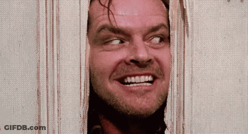 A Man Is Smiling While Looking Through A Door GIF
