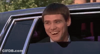 A Man Is Smiling While Sitting In A Car With His Head Out The Window . GIF