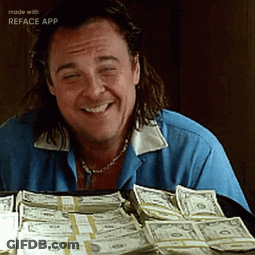 A Man Is Smiling While Sitting In Front Of A Pile Of Money Made By Reface App GIF