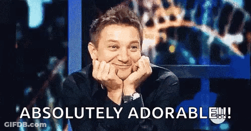 A Man Is Smiling With His Hands On His Face And The Words " Absolutely Adorable " Are Above Him GIF