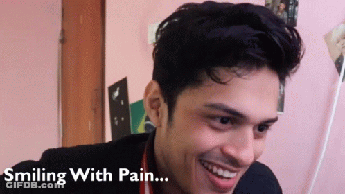 A Man Is Smiling With Pain Written Below Him GIF