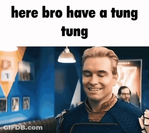 A Man Is Smiling With The Words Here Bro Have A Tung Tung Written Above Him GIF