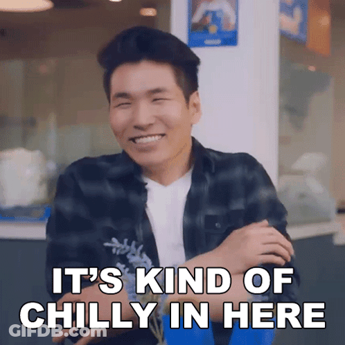 A Man Is Smiling With The Words It 'S Kind Of Chilly In Here Above Him GIF
