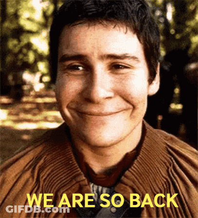 A Man Is Smiling With The Words We Are So Back Above Him GIF