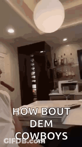 A Man Is Smoking A Cigar In A Living Room With The Words `` How Bout Dem Cowboys Am '' Written On It . GIF