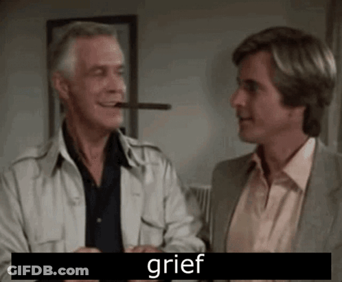 A Man Is Smoking A Cigar While Another Man Looks On . GIF
