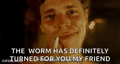 A Man Is Smoking A Cigarette And Smiling With The Words `` The Worm Has Definitely Turned For Your Friend '' . GIF