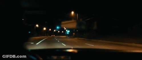 A Man Is Smoking A Cigarette While Driving A Car At Night . GIF