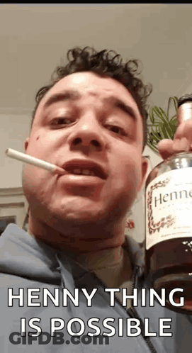 A Man Is Smoking A Cigarette While Holding A Bottle Of Hennessy Cognac . GIF