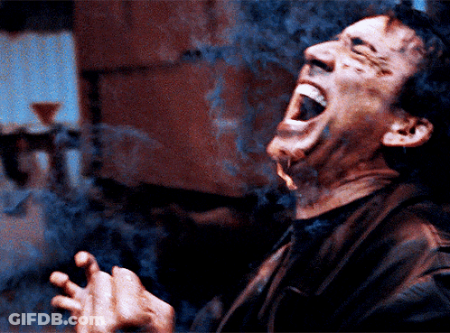 A Man Is Smoking A Cigarette With His Mouth Wide Open GIF