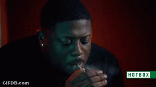 A Man Is Smoking A Cigarette With Smoke Coming Out Of His Mouth And A Hotbox Logo In The Corner . GIF