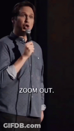 A Man Is Speaking Into A Microphone And The Words Zoom Out Are Above Him GIF