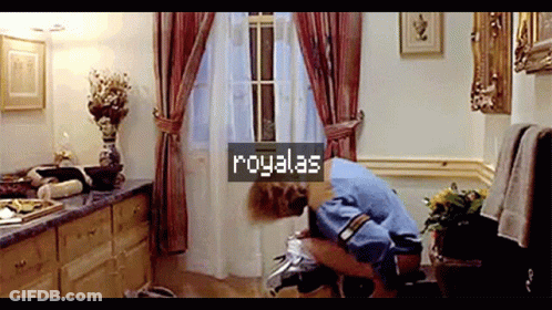 A Man Is Squatting On A Toilet In A Bathroom With A Sign That Says Royalas On It GIF