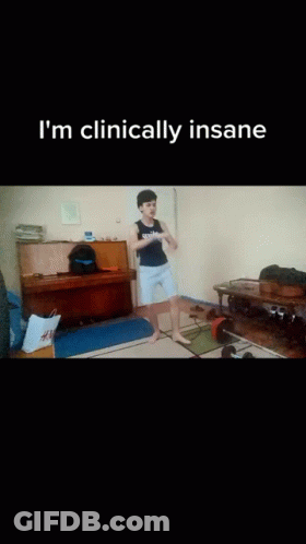 A Man Is Squatting On The Floor In A Living Room With The Words " I 'M Clinically Insane " On The Bottom GIF