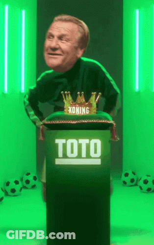 A Man Is Standing Behind A Podium That Says Toto On It GIF