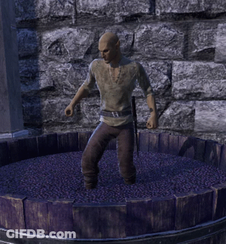 A Man Is Standing In A Barrel Of Grapes GIF