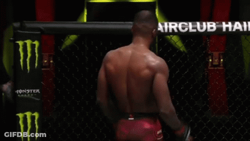 A Man Is Standing In A Boxing Ring In Front Of An Airclub Hair Sign GIF