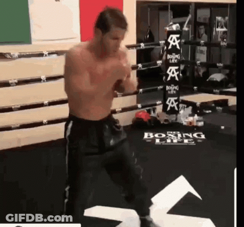 A Man Is Standing In A Boxing Ring With A Boxing Life Sign On The Floor GIF