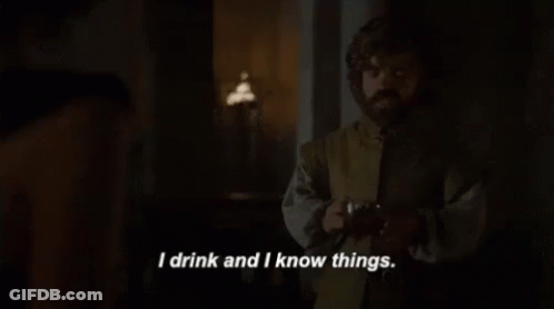 A Man Is Standing In A Dark Room Holding A Glass Of Wine And Saying `` I Drink And I Know Things '' . GIF