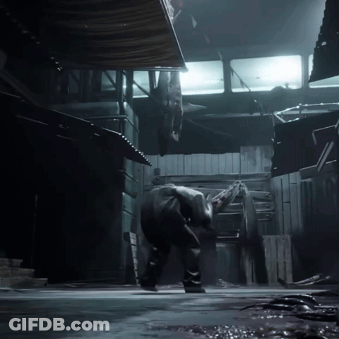 A Man Is Standing In A Dark Room With A Light Shining On Him GIF