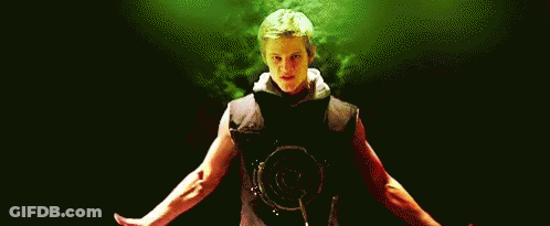 A Man Is Standing In A Dark Room With His Arms Outstretched And A Red Shirt On . GIF