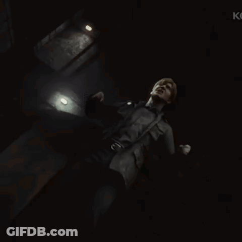 A Man Is Standing In A Dark Room With The Letter K On The Bottom Right GIF