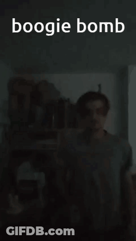 A Man Is Standing In A Dark Room With The Words Boogie Bomb Written Above Him GIF
