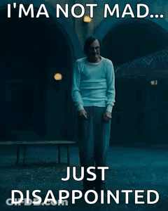 A Man Is Standing In A Dark Room With The Words `` I 'M Not Mad ... Just Disappointed '' Written On It . GIF
