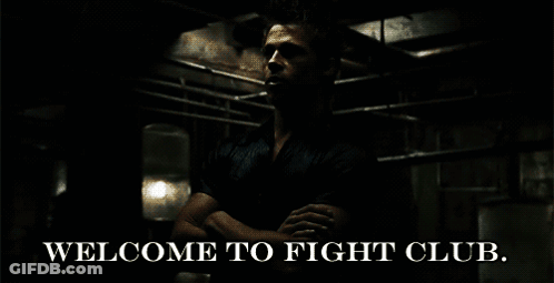 A Man Is Standing In A Dark Room With The Words Welcome To Fight Club GIF