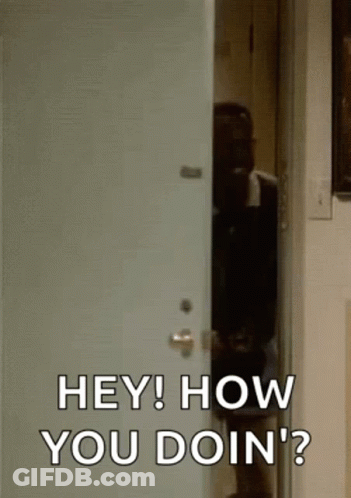 A Man Is Standing In A Doorway Talking To Another Man . GIF