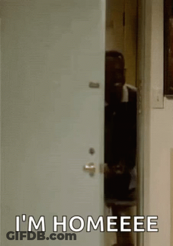 A Man Is Standing In A Doorway With The Words `` I 'M Homeeee '' Written On The Door . GIF