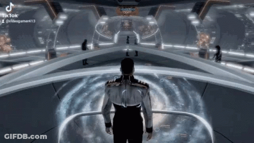 A Man Is Standing In A Futuristic Room In A Video Game And Looking At Something . GIF