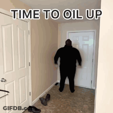 A Man Is Standing In A Hallway With The Words Time To Oil Up Written Above Him GIF