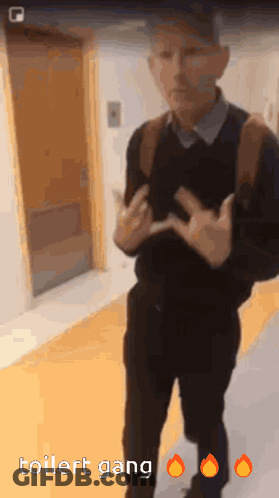 A Man Is Standing In A Hallway With The Words Toilet Gang On The Bottom Right GIF
