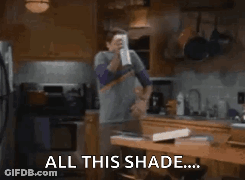 A Man Is Standing In A Kitchen Holding A Can Of Soda . GIF