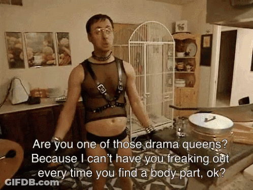 A Man Is Standing In A Kitchen With A Bird Cage In The Background GIF