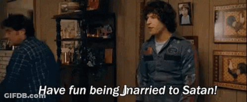 A Man Is Standing In A Living Room Talking To Another Man And Saying `` Have Fun Being Married To Satan '' . GIF